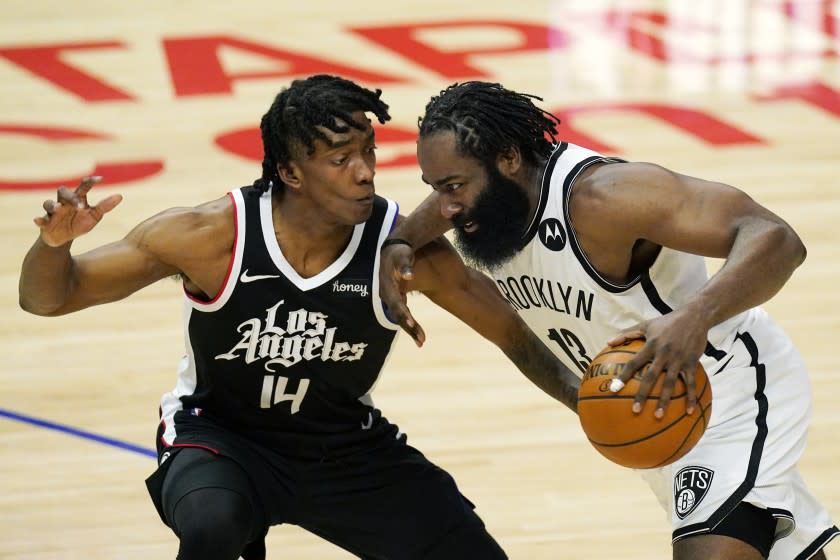 Brooklyn Nets guard James Harden, right, drives past Los Angeles Clippers guard Terance Mann during the second half of an NBA basketball game Sunday, Feb. 21, 2021, in Los Angeles. (AP Photo/Mark J. Terrill)