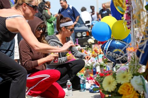 Wellwishers pay their respects at a memorial outside of Junior Seau's beach home in Oceanside, California. Former NFL star Seau committed suicide by shooting himself in the chest, autopsy results confirmed on Thursday, according to San Diego County authorities