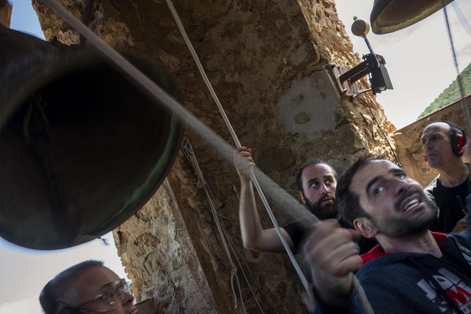 Students of the Vall d'en Bas School of Bell Ringers, perform playing all four bronze bells at the church bell tower of the12th-century Sant Romà church, at the tiny village of Joanetes, about two hours north of Barcelona, Spain, Saturday, July 29, 2024. A school set up to revive the manual ringing of church bells has graduated its first class of 18 students after learning their ringing skills. (AP Photo/Emilio Morenatti)