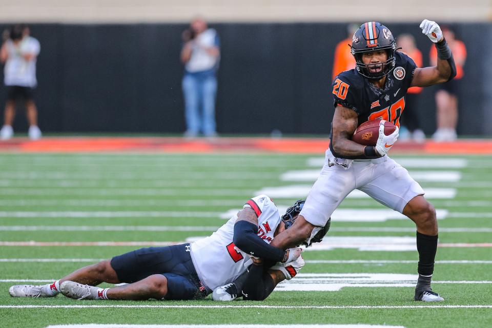 OSU's Dominic Richardson (20) is taken down by Texas Tech's Reggie Person Jr. in the fourth quarter of Saturday's 41-31 victory.