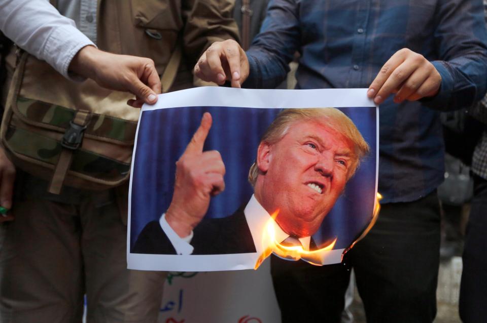 -FOTODELDIA- IRN001. TEHERÁN (IRÁN), 09/05/2018.- Un grupo de iraníes quema una fotografía del presidente estadounidense, Donald Trump, mientras participan en una protesta contra Estados Unidos frente a la antigua embajada estadounidense en Teherán (Irán) hoy, 9 de mayo del 2018, después de que el presidente estadounidense, Donald J. Trump, anunciase ayer que su país abandona el acuerdo nuclear con Irán alcanzado en 2015 junto a Rusia, China, Francia, Alemania y el Reino Unido, que imponía límites al programa nuclear de Irán a cambio del levantamiento de algunas de las sanciones internacionales. EFE/ Str