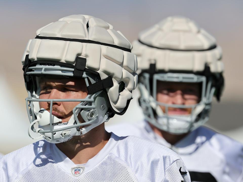 Two players wear bulky layers over their helmets called "guardian caps" meant to reduce the risk of concussion.