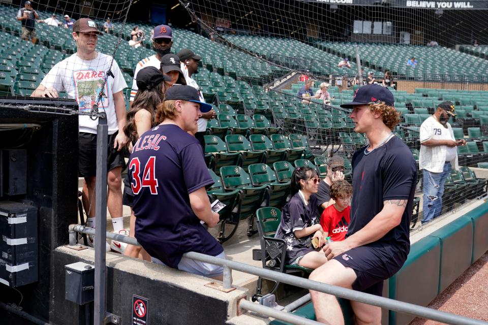 Cleveland Guardians' Zach Plesac, right, talks with family after the game between the Chicago White Sox and the Guardians was postponed due to multiple positive COVID-19 tests within the Guardians organization, Wednesday, May 11, 2022, in Chicago. (AP Photo/Charles Rex Arbogast)