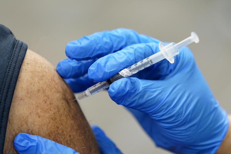 FILE - In this Jan. 5, 2021, file photo, a healthcare worker receives a second Pfizer-BioNTech COVID-19 vaccine shot in Southfield, Mich. On Friday, Jan. 8, 2021, The Associated Press reported on stories circulating online incorrectly asserting that COVID-19 vaccines that rely on messenger RNA technology will teach the body to attack itself, leading to autoimmune disease. The mRNA vaccines for COVID-19 contain a genetic code that trains the immune system to recognize the spike protein on the surface of the virus to generate an immune response and fight it. A lack of understanding around how mRNA vaccines work has led to a flurry of misinformation around the vaccines. (AP Photo/Paul Sancya, File)