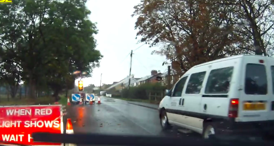 A white van was filmed driving past a learner as they waited at temporary traffic lights. (SWNS)