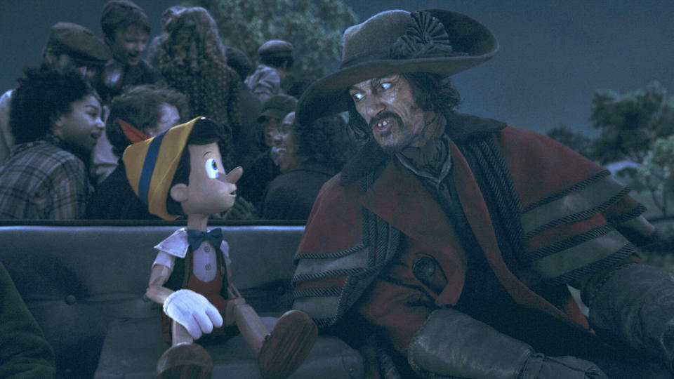 This image released by Disney shows Pinocchio, voiced by Benjamin Evan Ainsworth, left, and The Coachman, voiced by Luke Evans, in Disney's live-action film "Pinocchio." (Disney via AP)