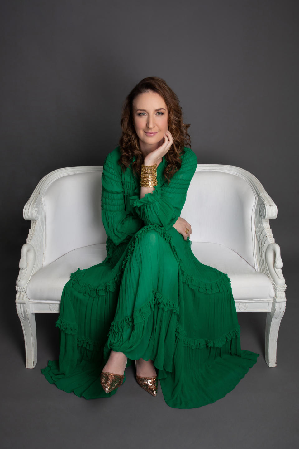 Woman in green dress sitting on a couch 