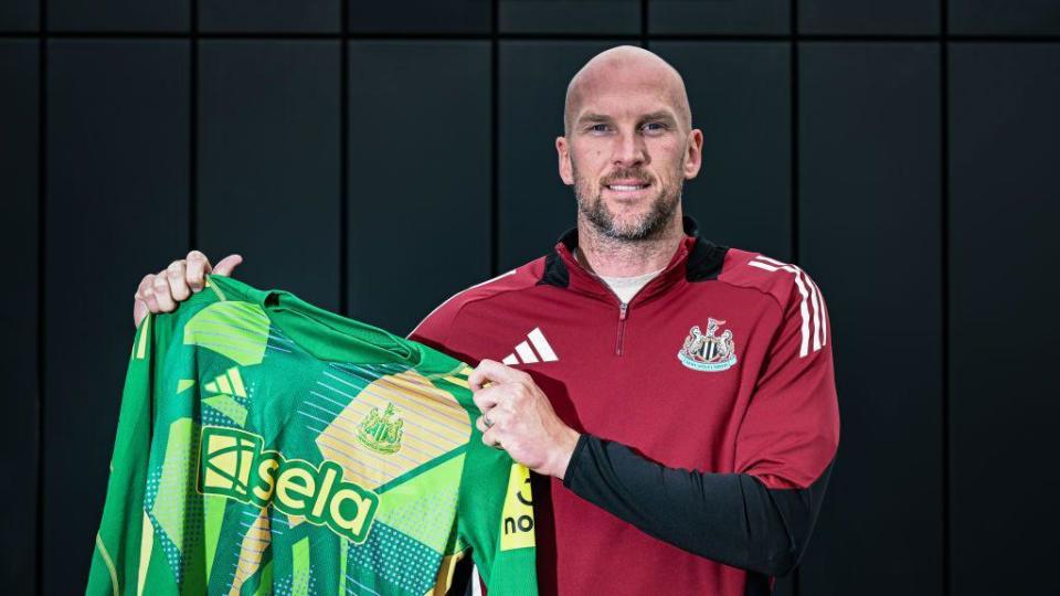 John Ruddy poses for photographs after signing for Newcastle United at the Newcastle United Training Ground