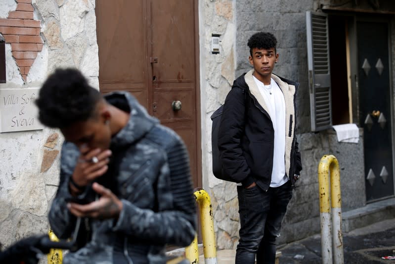 Nico Rodrigues, 21, stands and looks at passers-by close to the Santa Maria della Sanita Basilica in the Rione Sanita neighbourhood in Naples
