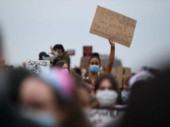 A woman holds up a sign during a Black Lives Matter protest rally in Hyde Park (PA)