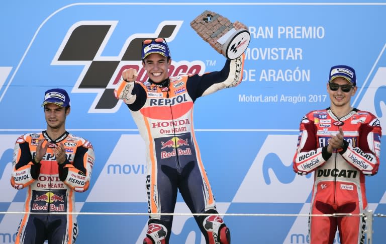 Repsol Honda Team's rider Marc Marquez (C) celebrates winning on the podium between second placed Dani Pedrosa (L) and Jorge Lorenzo on September 24, 2017