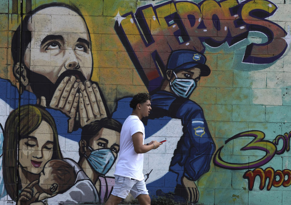 FILE - A pedestrian walks past a mural dedicated to heroes featuring President Nayib Bukele in the Soyapango neighborhood of San Salvador, El Salvador, Feb. 28, 2023. Bukele has been sharply criticized internationally for having “systematically committed grave human rights violations″ in his gang crackdown. But the resulting sharp drop in violence combined with an elaborate media machine has earned Bukele a strong populist base both within El Salvador and abroad. (AP Photo/Salvador Melendez, File)