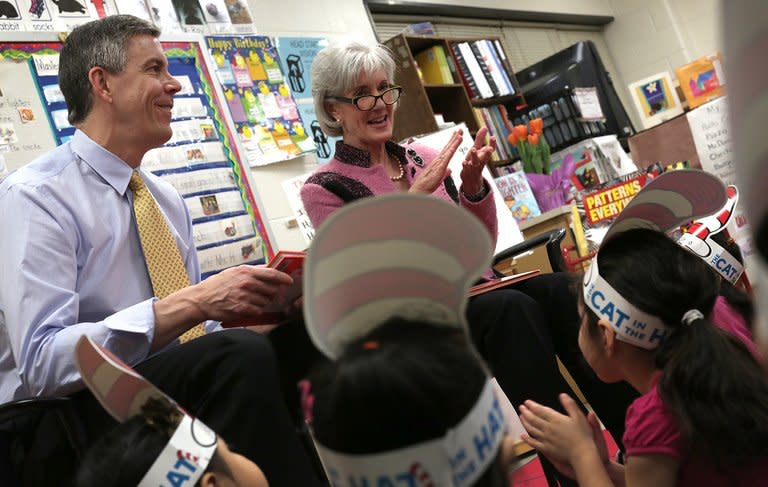 Education Secretary Arne Duncan (L) and HHS Secretary Kathleen Sebelius (R) read the Dr. Seuss book "Green Eggs and Ham" to students enrolled on March 1, 2013 in Takoma Park, Maryland