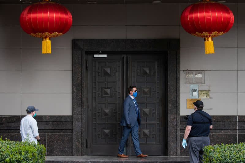 Plain clothes U.S. security officials surround the entrance of China’s Consulate after Chinese employees left the building, in Houston