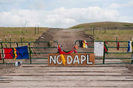 Signs left by protesters demonstrating against the Energy Transfer Partners Dakota Access oil pipeline sit at the gate of a construction access road where construction has been stopped for several weeks due to the protests near the Standing Rock Sioux reservation in Cannon Ball, North Dakota, U.S. September 6, 2016. REUTERS/Andrew Cullen