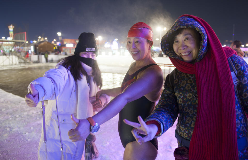 <p>A winter swimmer takes a photo with tourists at Ice and Snow World park on Jan. 4 in Harbin, China. (Photo: Tao Zhang/Getty Images) </p>