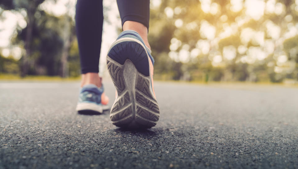 Woman feet running on road closeup on shoe. Young fitness women runner legs ready for run on the road. Sports healthy lifestyle concept.