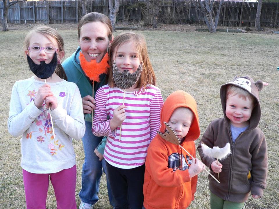 This Friday, Feb. 28, 2014 photo shows, from left, family friend Tatum Marsh, 7, parent Kristi Ainslie, and her children, Riley Ainslie, 6, Dillon Ainslie, 2, and Connor Ainslie, 2, modeling their leprechaun beards made from faux fur and cardboard, which provide a fun way to celebrate St. Patrick's Day, in Arvada, Colo. Making and taking handmade St. Patrick's Day props cranks up the fun at parades and parties. Instructions for making this craft are in the March 2013 issue of FamilyFun magazine, available online at www.parents.com. (AP Photo/Jennifer Forker)