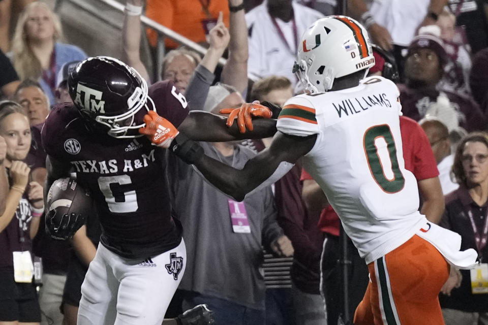 Miami safety James Williams (0) grabs the face mask of Texas A&M running back Devon Achane (6) while trying to tackle him during the first quarter of an NCAA college football game Saturday, Sept. 17, 2022, in College Station, Texas. (AP Photo/Sam Craft)