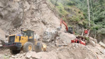 In this handout photograph provided by the Jammu and Kashmir Government's Department of Disaster Management, earthmovers work to clear the site where an under construction tunnel collapsed in Ramban district, in Indian-controlled Kashmir, Friday, May 20, 2022. An official said Friday that 10 workers were trapped after part of an under construction road tunnel collapsed in the Himalayan region. (Jammu and Kashmir Government's Department of Disaster Management via AP)