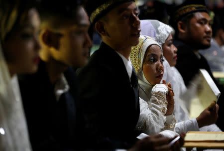 Couples take part in a mass wedding organised by the city government as part of New Year's Eve celebrations in Jakarta, Indonesia, December 31, 2017. REUTERS/Darren Whiteside