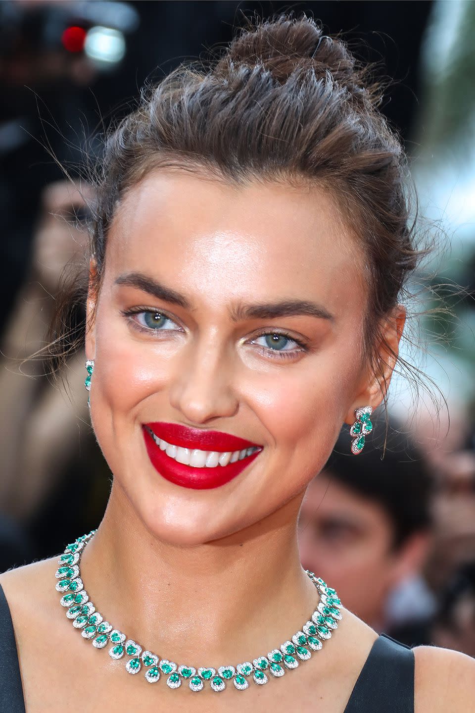 <p>Irina Shayk modelled the modern way to wear hot red lips; with barely-there eye make-up and a perfectly imperfect messy bun. </p>