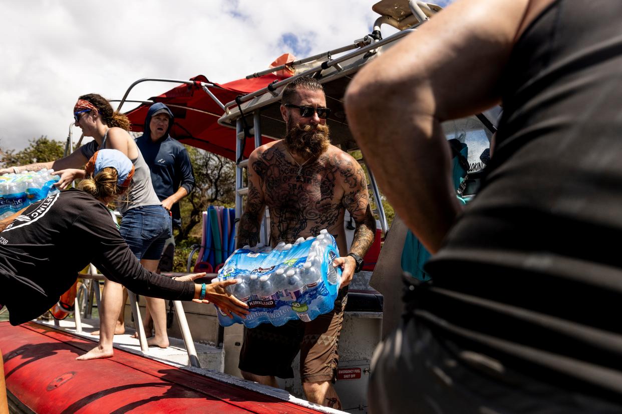 Volunteers load supplies onto a boat for West Maui at the Kihei boat landing (San Francisco Chronicle)