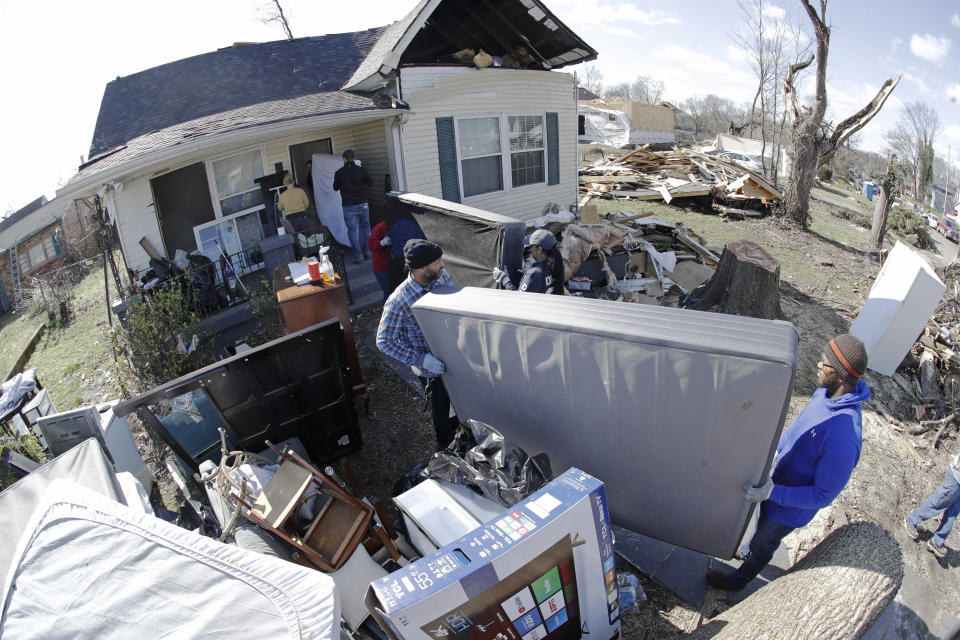 A group of volunteers moves items salvaged from a damaged home Friday, March 6, 2020, in Nashville, Tenn. Residents and businesses face a huge cleanup effort after tornadoes hit the state Tuesday. (AP Photo/Mark Humphrey)