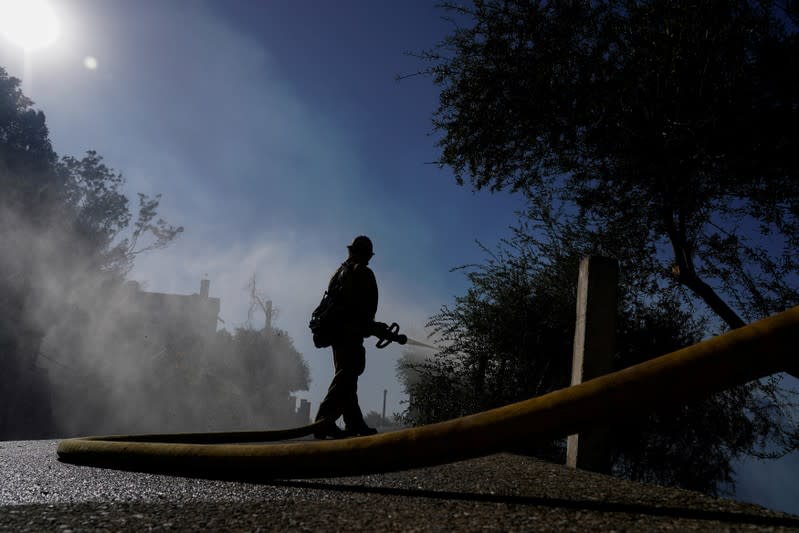 FILE PHOTO: A firefighter tackles the Dexter fire on a hillside near Riverside