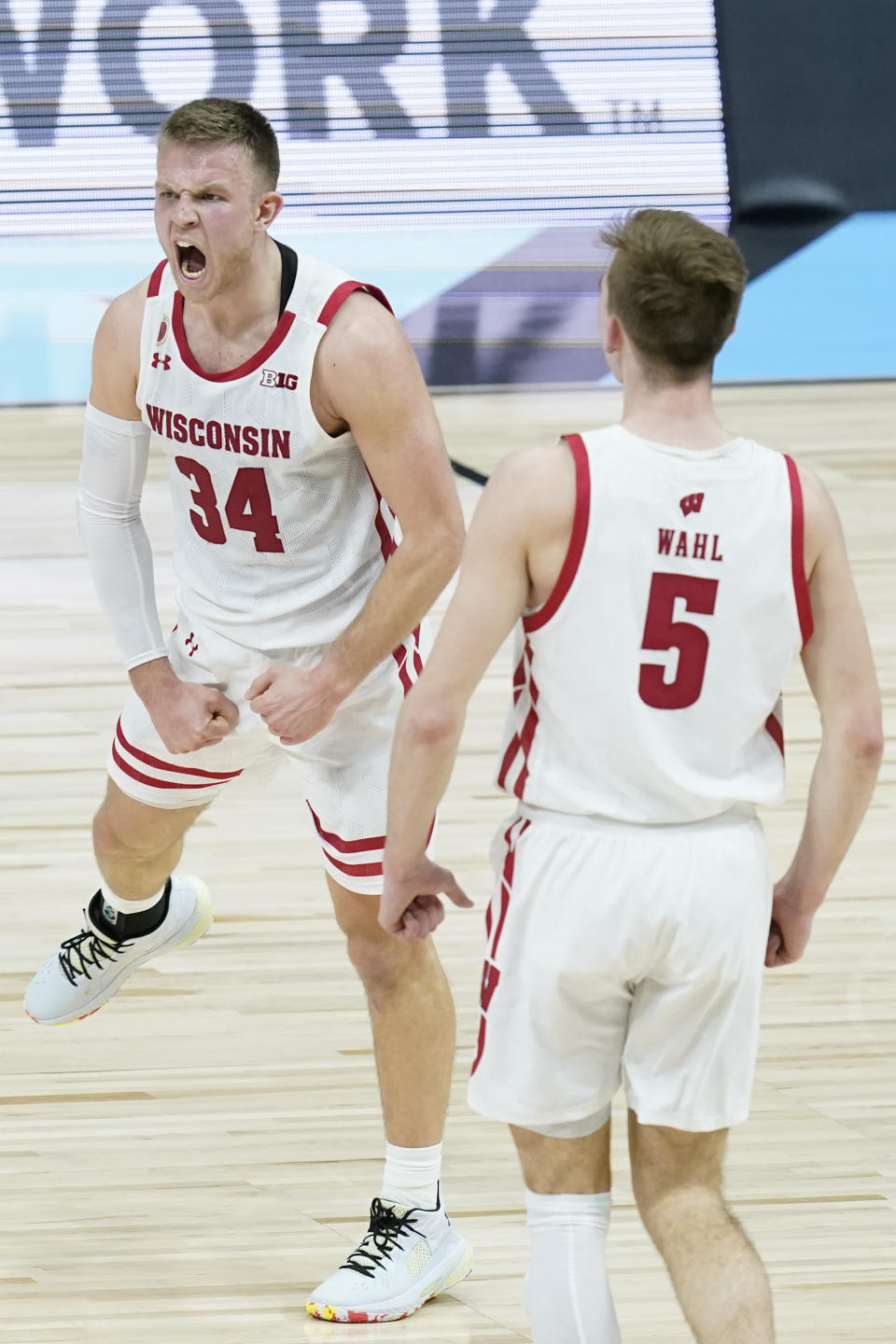 Wisconsin's Brad Davison (34) celebrates with Tyler Wahl (5) after Davison hit s shot during the second half of an NCAA college basketball game against Penn State at the Big Ten Conference tournament, Thursday, March 11, 2021, in Indianapolis. (AP Photo/Darron Cummings)
