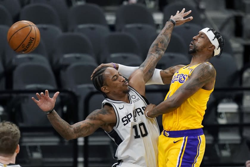 Lakers guard Kentavious Caldwell-Pope passes the ball around Spurs guard DeMar DeRozan during their game Dec. 30, 2020.