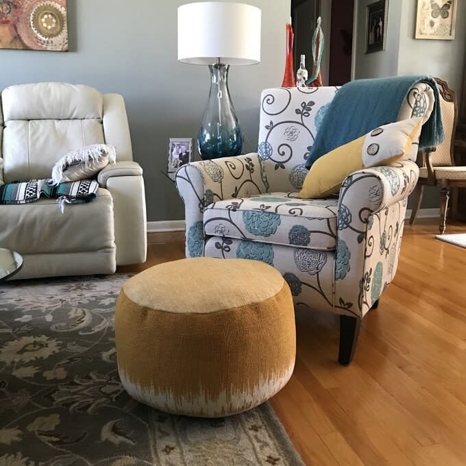 A patterned armchair and a yellow ottoman in a living room setting for home decor inspiration