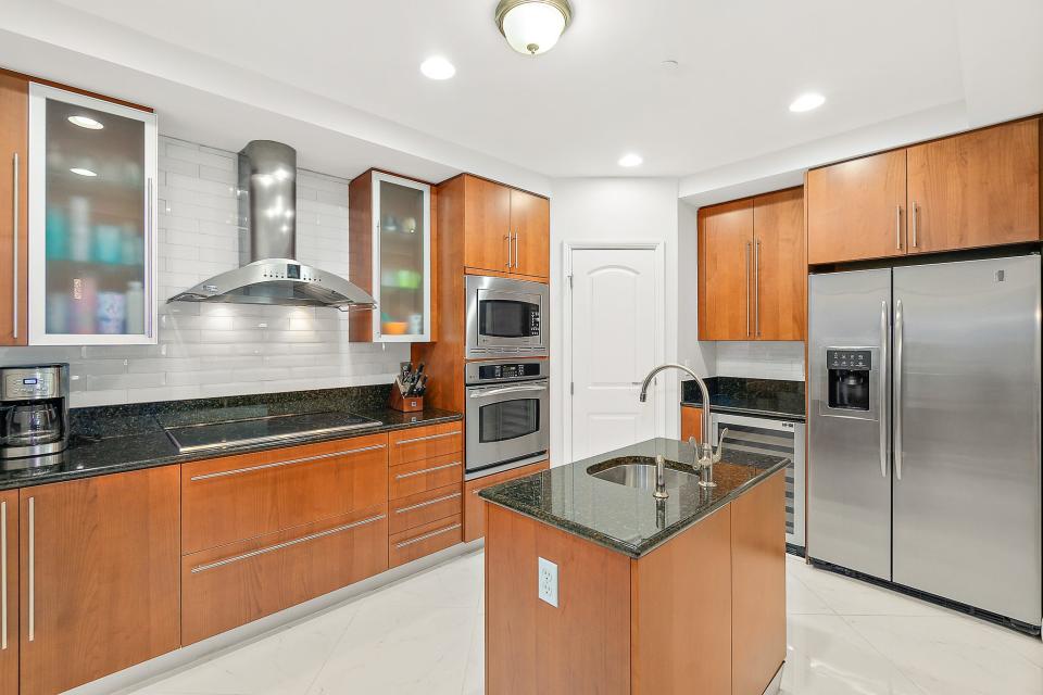 This high-end kitchen features top-of-the-line stainless-steel appliances, a center-island sink and beautiful subway-tile backsplash.