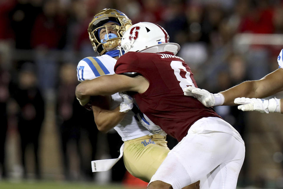 Stanford linebacker Tristan Sinclair (8) wraps up UCLA wide receiver Logan Loya during the second half an NCAA college football game, Saturday, Oct. 21, 2023, in Stanford, Calif. (AP Photo/Scot Tucker)