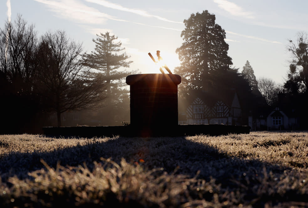 The sun rises over a sun dial depicting a cricketer as frost covers the ground on Holyport Green, Holyport, Berkshire (Picture: PA)