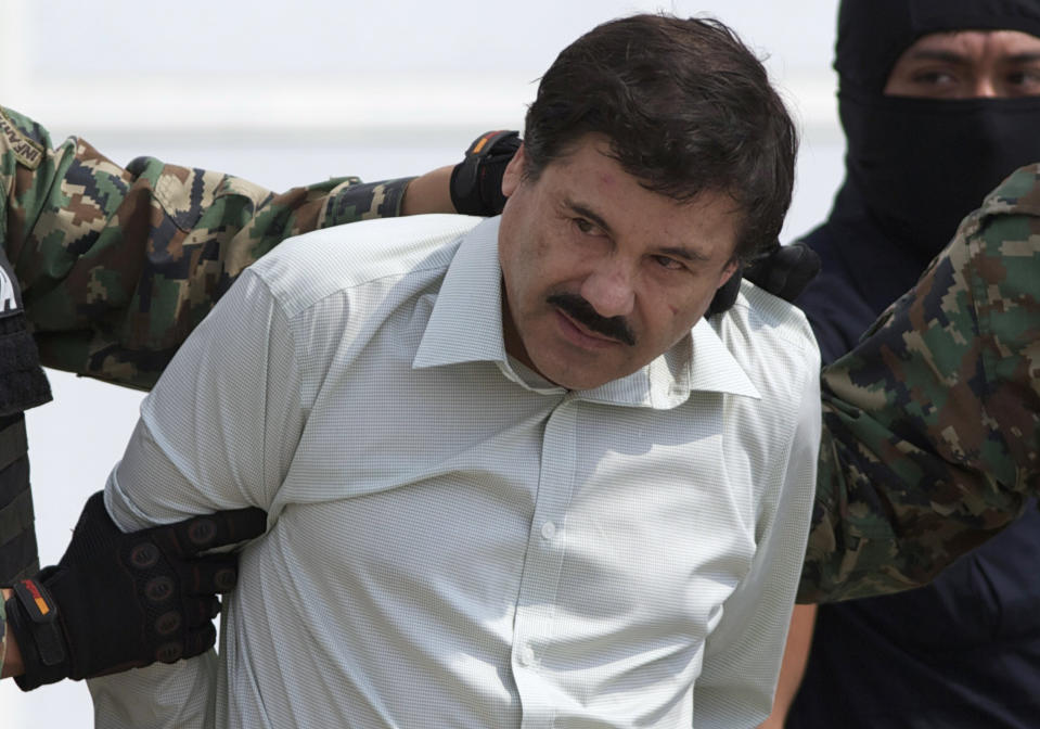 FILE - This Feb. 22, 2014 file photo shows Joaquin "El Chapo" Guzman, the head of Mexico's Sinaloa Cartel, being escorted to a helicopter in Mexico City following his capture overnight in the beach resort town of Mazatlan, Mexico. With Sinaloa cartel boss Joaquín “El Chapo” Guzmán serving a life sentence, his sons steered the family business into fentanyl, establishing a network of labs churning out massive quantities they smuggled into the U.S., prosecutors in the U.S. revealed in an indictment unsealed April 14, 2023 in Manhattan. (AP Photo/Eduardo Verdugo, File)