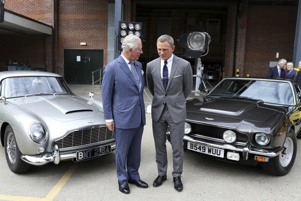 Britain's Prince Charles talks with actor Daniel Craig, right, during a visit to the set of the 25th James Bond film at Pinewood Studios in Iver Heath, southern England, Thursday June 20, 2019. (Chris Jackson/PA via AP)