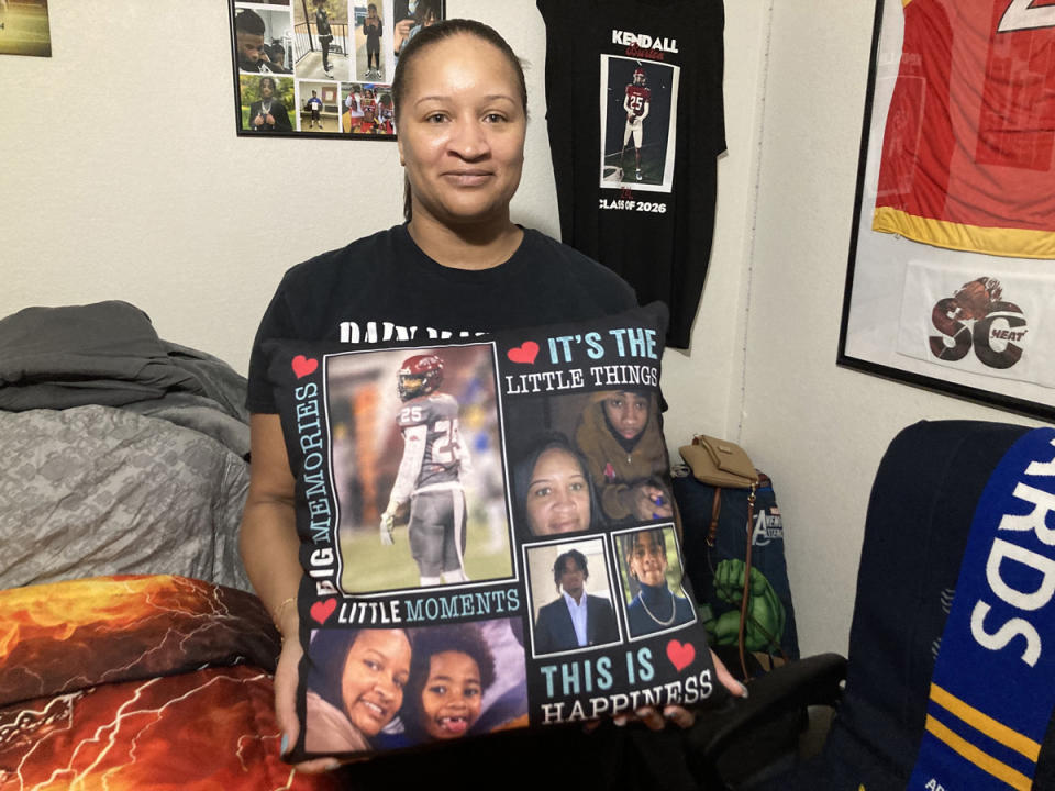  Shaketa Simmons holds a pillow emblazoned with images of her son, Kendall, who was killed Jan. 12. (Jo Napolitano/The 74)