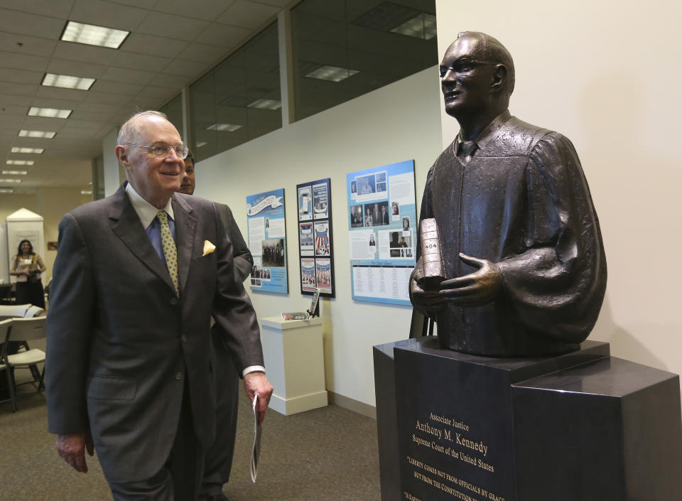 Former Supreme Court Justice, Anthony Kennedy, passes a statue of himself during a break at Constitution Day 2018 held at The Justice Anthony M. Kennedy Library and Learning Center, Friday, Sept. 28, 2018, in Sacramento, Calif. Kennedy did not answer questions about the hearings of Brett Kavanaugh, who has been appointed to replace Kennedy on the Supreme Court. (AP Photo/Rich Pedroncelli)