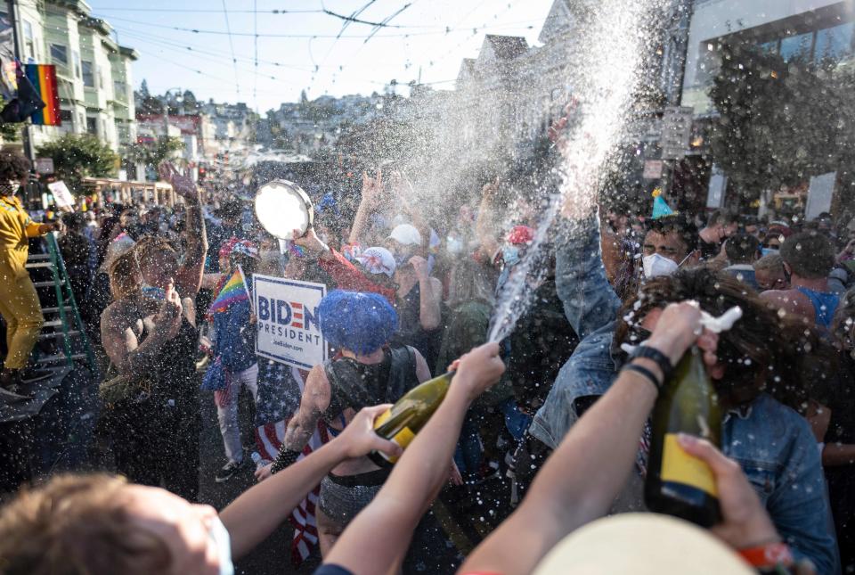 People spray champagne as they celebrate Joe Biden being elected President of the United States in the Castro district of San Francisco, California on November 7, 2020. - Democrat Joe Biden has won the White House, US media said November 7, defeating Donald Trump and ending a presidency that convulsed American politics, shocked the world and left the United States more divided than at any time in decades. (Photo by JOSH EDELSON / AFP) (Photo by JOSH EDELSON/AFP via Getty Images)