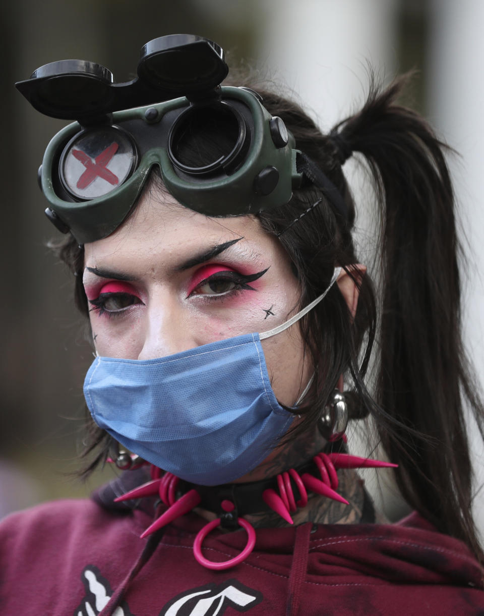 Un miembro de la comunidad LGBT utiliza una mascarilla mientras observa a la cámara durante una protesta en contra de los recientes asesinatos sin resolver de varios de sus compañeros en Bogotá, Colombia, el viernes 3 de julio de 2020. (AP Foto/Fernando Vergara)