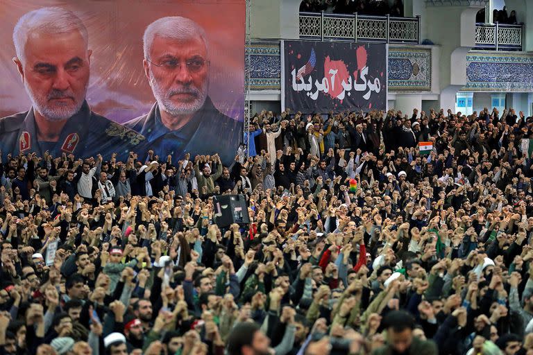 Una foto proporcionada por la oficina del Líder Supremo Ayatollah Ali Khamenei muestra a iraníes durante la oración del viernes 17 de enero de 2020, bajo los retratos del comandante iraní Qassem Soleimani, a la izquierda, y el líder de la milicia iraquí Abu Mahdi al-Muhandis, ambos asesinados en un