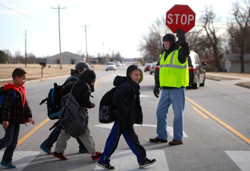 A News-Leader file photo shows students crossing a road near Harrison Elementary with the help of a crossing guard.