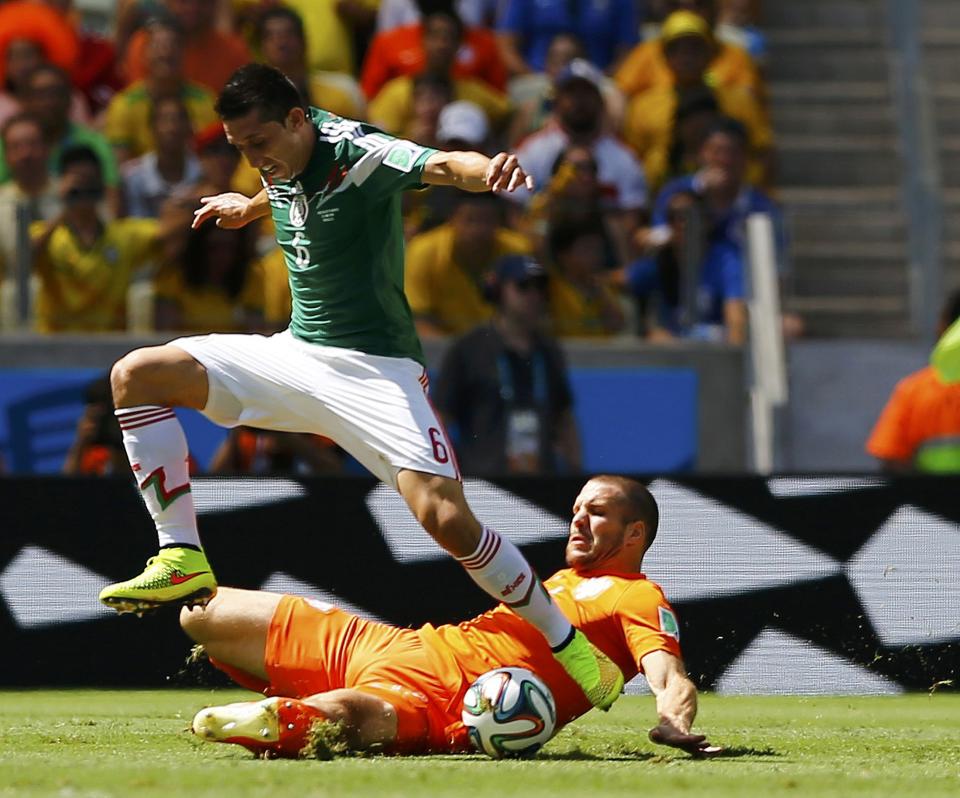 Mexico's Herrera jumps over Vlaar of the Netherlands during their 2014 World Cup round of 16 game at the Castelao arena in Fortaleza