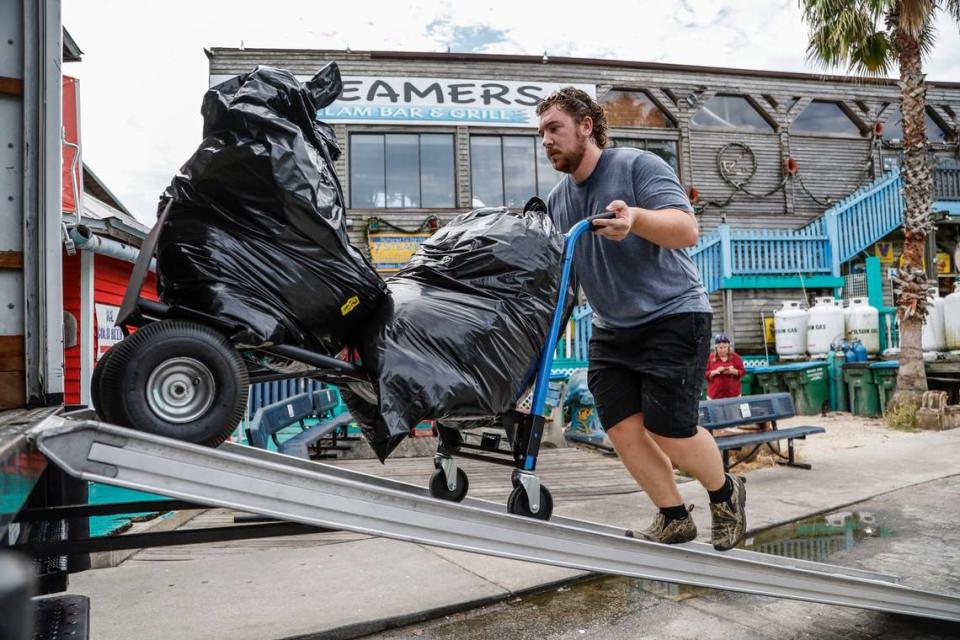 Ethan Campbell loads up a truck with bags of merchandise gathered from the Island Trading Post as people prepare for Hurricane Idalia in Cedar Key, Florida on Tuesday, August 29, 2023.