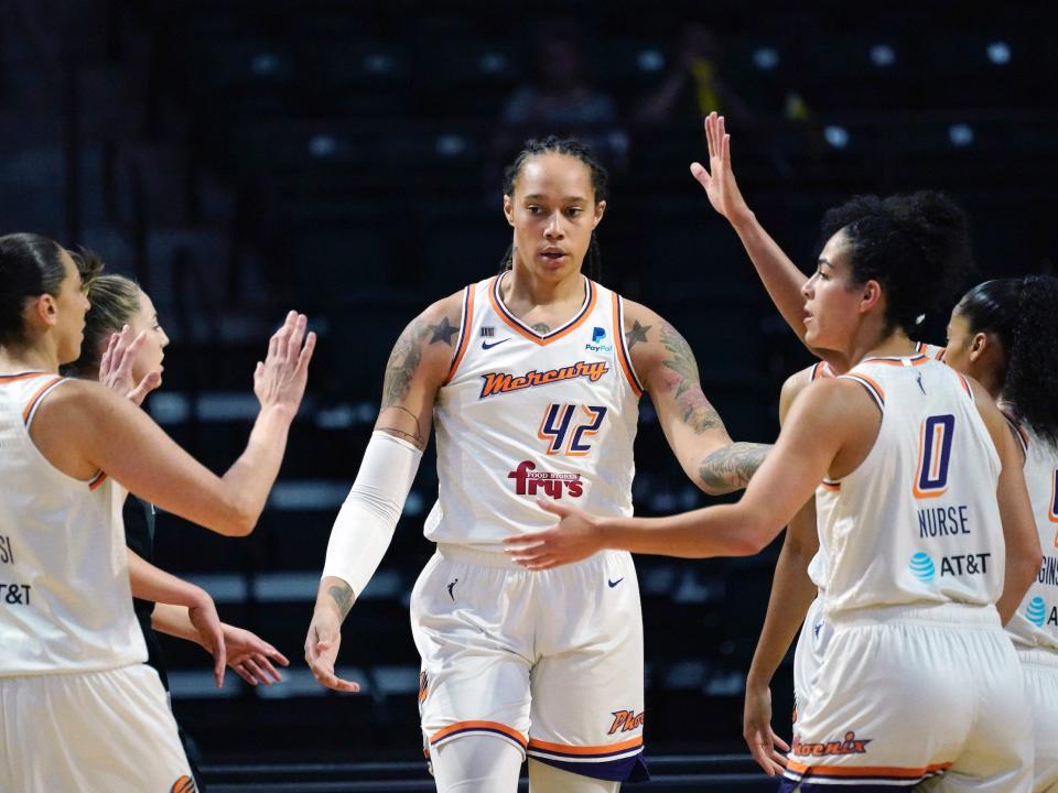 Brittney Griner high fives her Phoenix Mercury teammates.