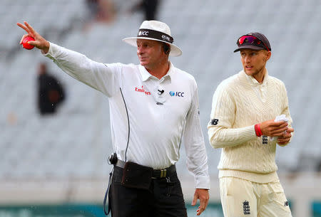 Cricket - Test Match - New Zealand v England - Eden Park, Auckland, New Zealand, March 24, 2018. England's captain Joe Root talks with umpire Paul Reiffel as they walk off the field during a rain delay on the third day of the first cricket test match. REUTERS/David Gray