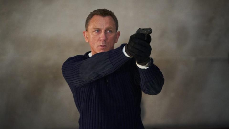 daniel craig as james bond pointing a handgun while wearing a black shirt