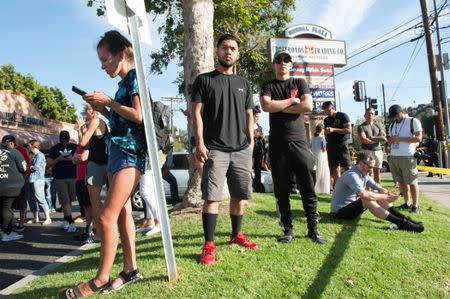 Trader Joe's employees and others wait in a parking lot near a Trader Joe's store where a hostage situation unfolded in Los Angeles, California, July 21, 2018. REUTERS/Andrew Cullen