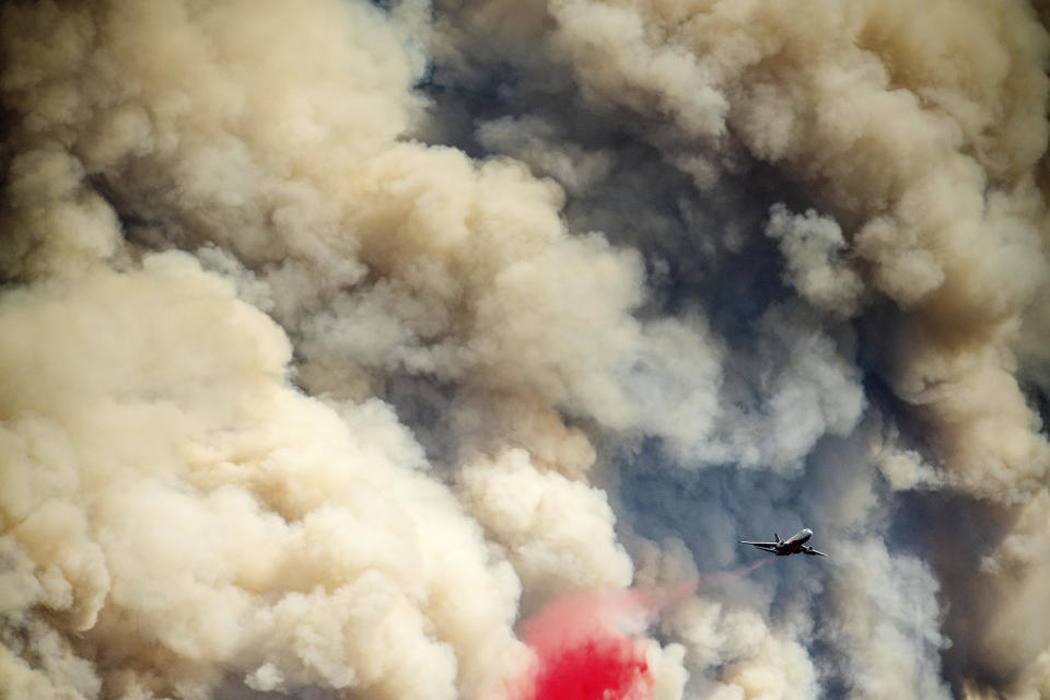 Viewed from the Foresthill community in Placer County, Calif., an air tanker drops retardant on the Mosquito Fire as it burns near Volcanoville on Thursday, Sept. 8, 2022. (AP Photo/Noah Berger)